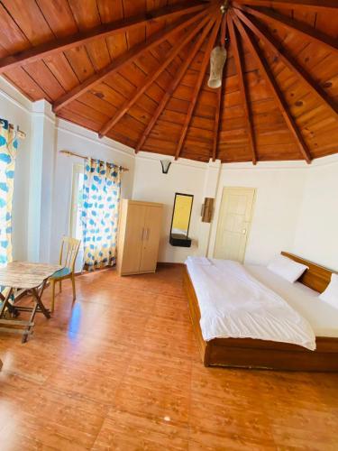 a bedroom with a large bed and a wooden ceiling at The Hidden Cove in Bhīm Tāl