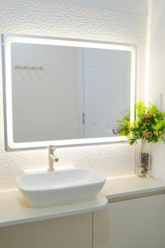 a bathroom sink with a large mirror above it at Airport Gem with Pool and Gym in Pusok