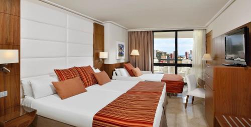 a hotel room with two beds and a television at Meliá Benidorm in Benidorm