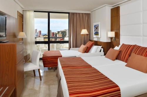 a hotel room with two beds and a balcony at Meliá Benidorm in Benidorm