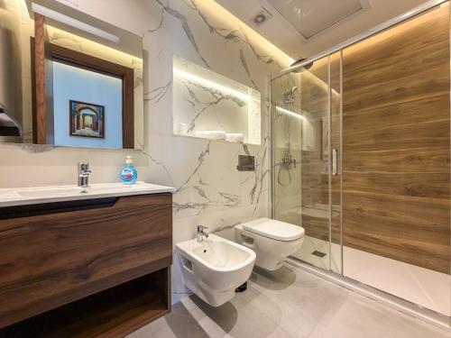 a bathroom with a toilet and a sink and a shower at Résidence Oscar - Pool & View in M'diq