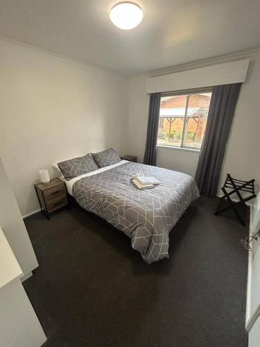 a bedroom with a large bed and a window at Comara Jindabyne Unit 2 in Jindabyne