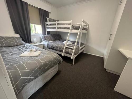 a bedroom with a bed and bunk beds in it at Comara Jindabyne Unit 2 in Jindabyne