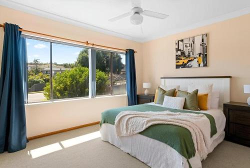 a bedroom with a bed and a large window at Cheerful Beach house at Redhead - BBQ, Beach, Views in Redhead