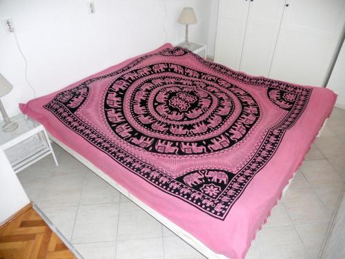 a pink blanket on a bed in a room at Apartment Milano in Matulji