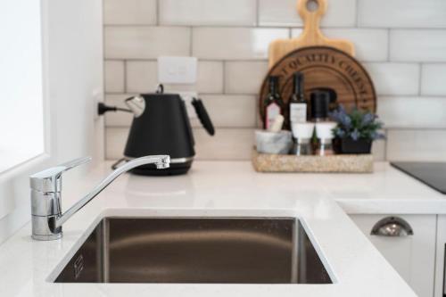 a kitchen counter with a sink and a kettle at Clareview Cottage in Rotorua