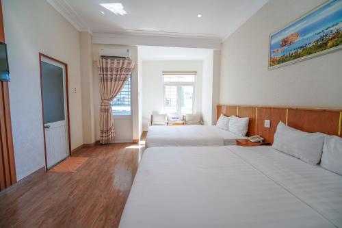a hotel room with two beds and a window at King Hotel in Quy Nhon