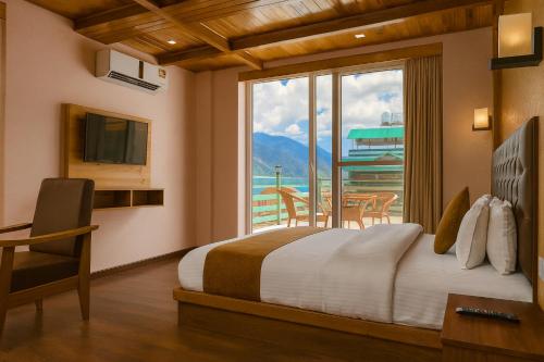 a bedroom with a bed and a window with a table at Hotel The Fortune Luxury Rooms Near Mall Road Manali By Vistas - Best Selling Centrally Heated Property 2025-26 in Manāli