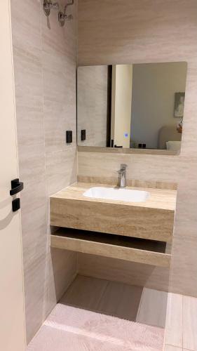 a bathroom with a sink and a mirror at August in Jazan