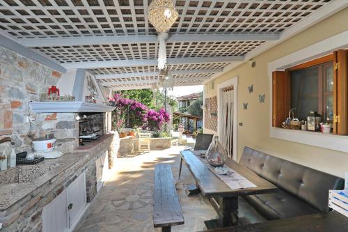 a patio with a wooden bench and a table at Sklavos Studios skopelos in Neo Klima