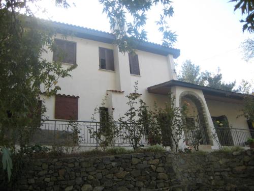 Casa blanca con valla y pared de piedra en Flora's House, en Spilia