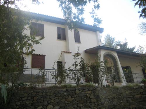 a white house with a fence and a stone wall at Flora's House in Spilia