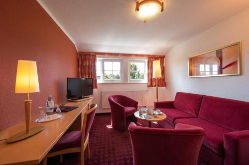 a hotel room with a couch and a table at Hotel und Restaurant Röbler Thor in Wittstock