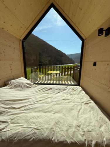 a bed in a room with a large window at Camping Pier10 in Bourscheid