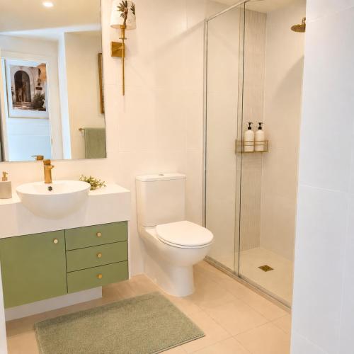 a bathroom with a toilet and a sink and a shower at Luxury Renovated Resort Studio Apartment - Oaks Pacific Blue in Salamander Bay