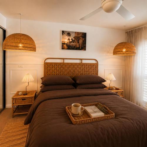 a bedroom with a large bed with a tray on it at Luxury Renovated Resort Studio Apartment - Oaks Pacific Blue in Salamander Bay