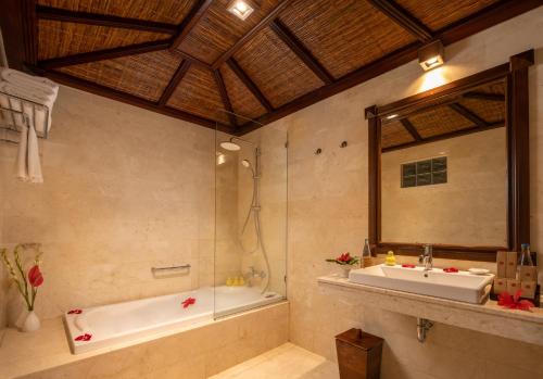 a bathroom with a bath tub and a sink at Hotel Tjampuhan Spa in Ubud