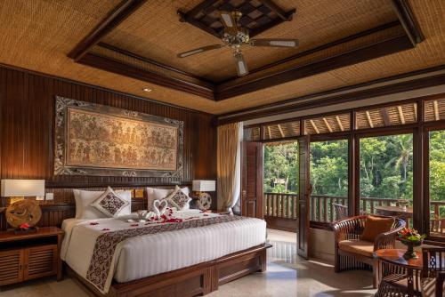 a bedroom with a large bed and a balcony at Hotel Tjampuhan Spa in Ubud
