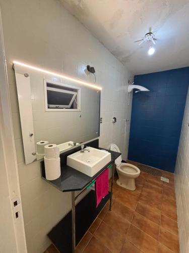 a bathroom with a sink and a toilet at Apartamento central bem localizado in Pelotas