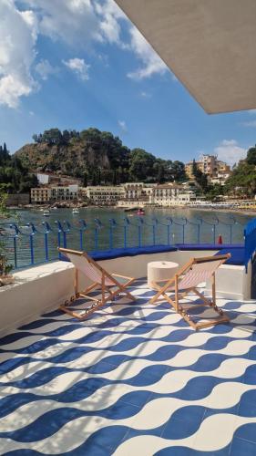 a balcony with benches and a view of the water at La Prua in Taormina