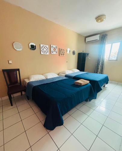 a bedroom with two beds with blue sheets at Hotel Peccato Originale in Tuxtla Gutiérrez