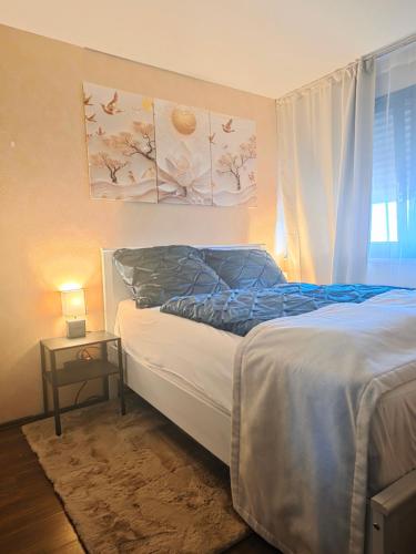 a bedroom with a bed and a table with a lamp at HappyNest in Böblingen