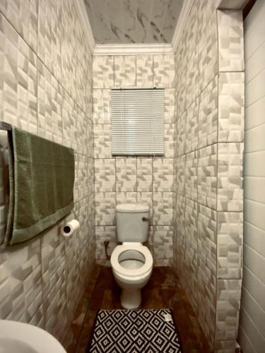 a bathroom with a toilet and a sink at Mukomani Guesthouse in Soshanguve