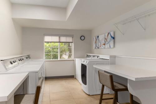 a kitchen with white appliances and a table and chairs at Candlewood Suites Oak Harbor by IHG in Oak Harbor