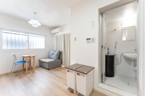 a room with a bathroom with a sink and a chair at JUJO Inn in Tokyo