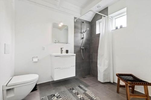 a white bathroom with a toilet and a shower at 8574-Grenaa-Annavej-13 in Gjerrild
