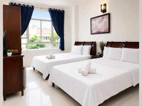 a bedroom with two beds and a window at SG Cozy2 Hotel - Pham Ngu Lao Street in Ho Chi Minh City