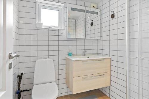 a white tiled bathroom with a sink and a toilet at FY421-Frorup-Grantoften-3 in Frørup