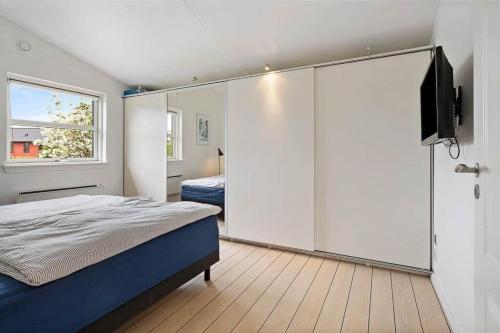 a bedroom with a bed and a flat screen tv at FY421-Frorup-Grantoften-3 in Frørup
