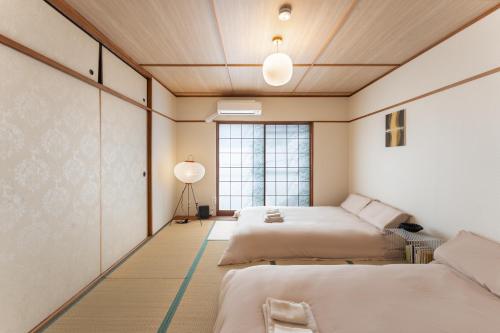 a bedroom with three beds and a window at JUJO Inn in Tokyo