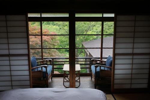 a bedroom with a view of a balcony with windows at Shiroyamakan in Shirakawa