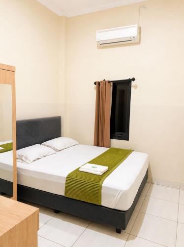 a bedroom with a bed and a air conditioner at Solota Boutique Hotel Syariah in Bonorejo
