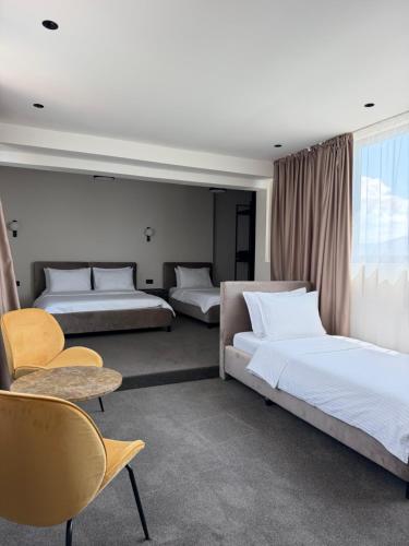 ein Schlafzimmer mit zwei Betten, einem Tisch und Stühlen in der Unterkunft Hotel Keto in Podgorica