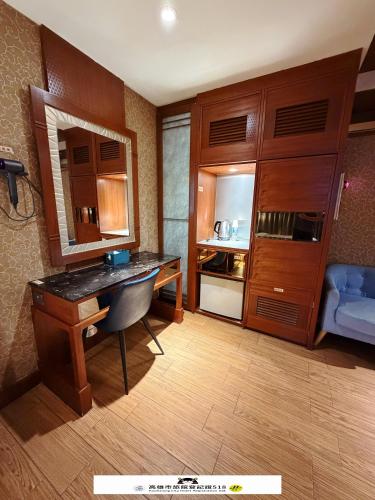 a hotel room with a desk and a blue couch at Venice Motel in Kaohsiung