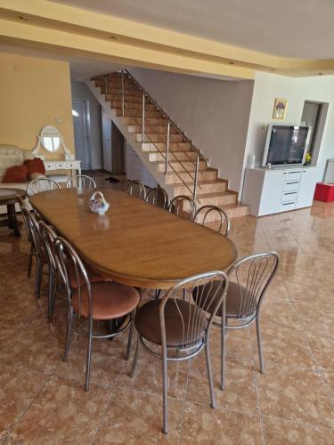 a table and chairs in a room with a staircase at apartament maia 2 in Turda