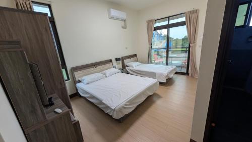 a bedroom with two beds and a window at Ronglai Inn in Jinning