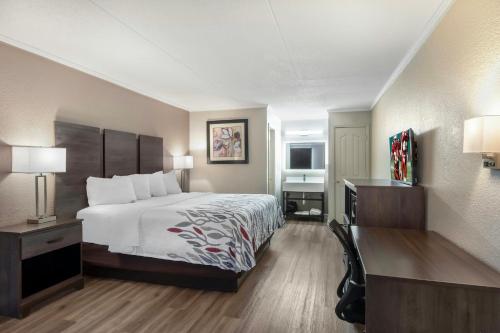 a hotel room with a bed and a desk at Red Roof Inn Manchester, TN in Manchester