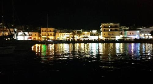 a city lit up at night with a body of water at Hotel Coronis in Naxos Chora