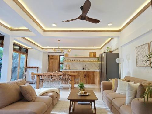 a living room with a couch and a ceiling fan at Three-Bedroom Luxury Garden Villa by Sing Siargao in General Luna