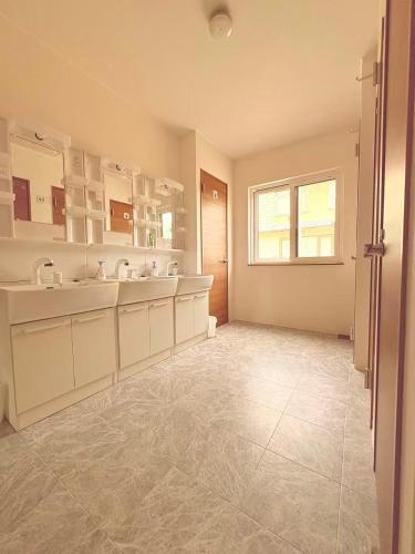 a large bathroom with two sinks and a window at Hitori Otaru in Otaru