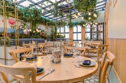 a dining room with tables and chairs and plants at Faranda Collection Barranquilla, a member of Radisson Individuals in Barranquilla
