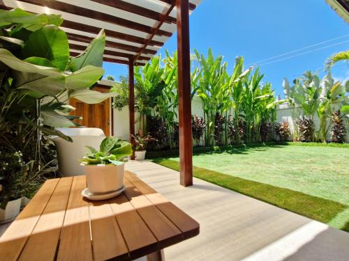 a patio with a wooden table and some plants at Three-Bedroom Luxury Garden Villa by Sing Siargao in General Luna