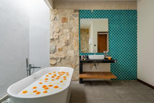 a bathroom with a bath tub and a sink at THE SAND Suites & Villas in Ngurah Rai International Airport