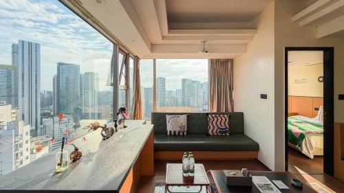 a living room with a couch and a large window at INVIS Urban High-rise Suites in Chengdu