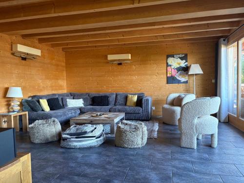 a living room with a couch and a table and chairs at Chalet La Renarde in Villars-sur-Ollon