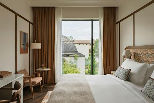 a hotel room with a bed and a large window at Stradom House Hotel & Spa, Autograph Collection in Krakow